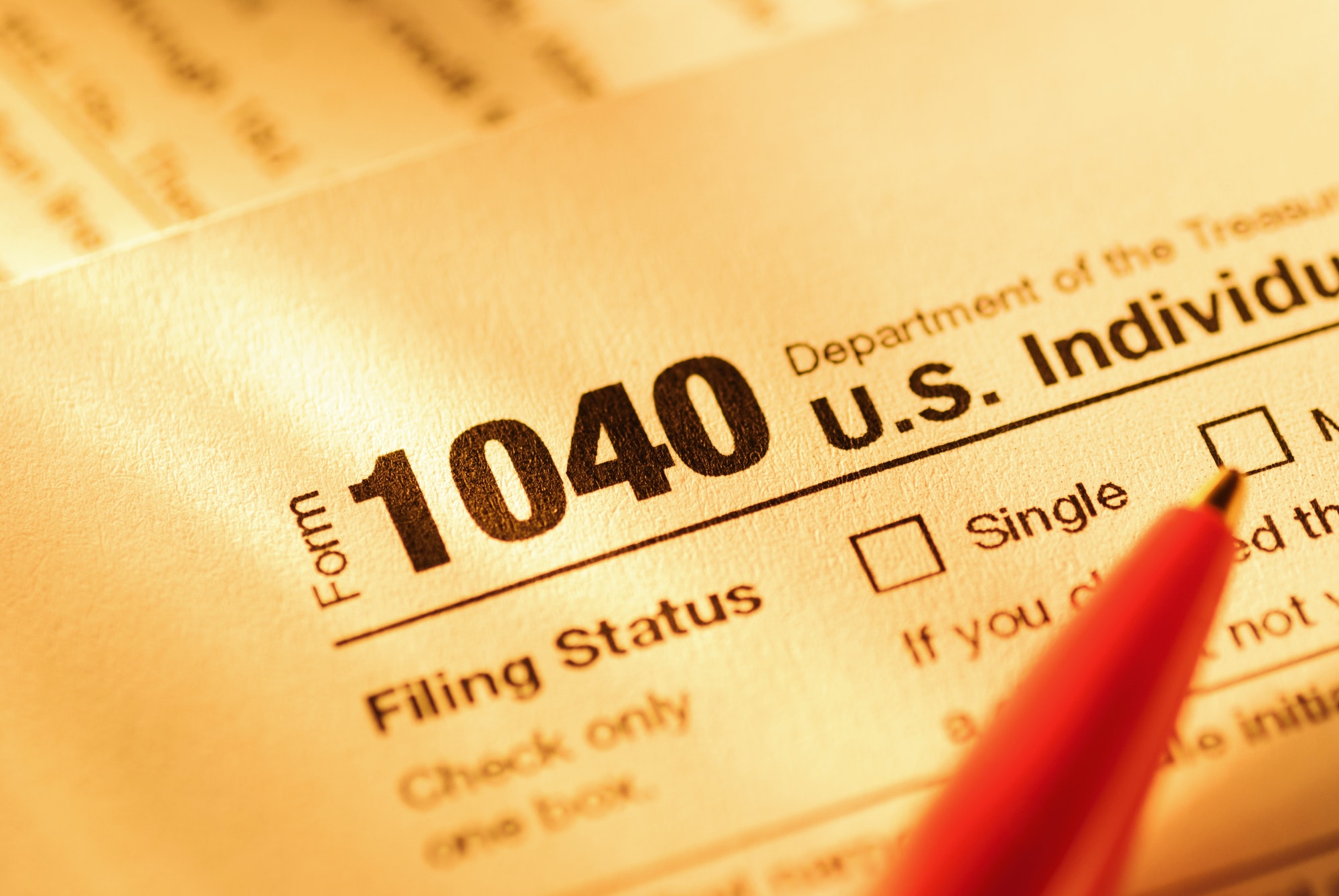Form 1040 with red pen for US tax declaration